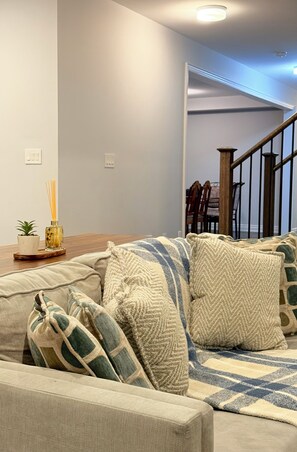 A living room with a sofa, a coffee table, and a potted plant. - Sleeps 16 and more | Bedrooms with ensuite washrooms (Springwater)