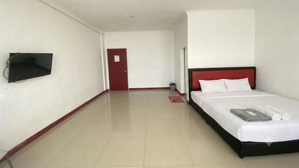 A hotel room with a bed, a television mounted on the wall, a door, and a tiled floor. - Hotel O near Nagoya Hill Mall formerly J (Batam)