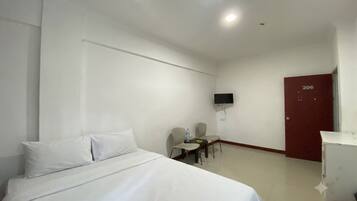 Habitación de hotel con cama, escritorio, silla, televisor montado en la pared y puerta con el número 206.
