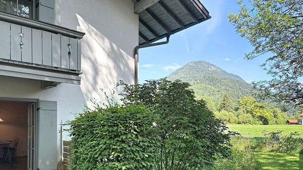 A house with a balcony, a small garden, and a mountain in the background. - Bergzeit by Interhome (Oberaudorf)