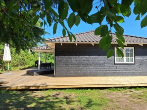 A wooden cabin with a covered patio, a window, and a door. - "Ethil" - 600m from the sea by Interhome (Gilleleje)