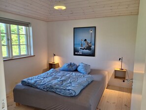 A bedroom with a bed, two bedside tables, a poster on the wall, and a window. - "Ethil" - 600m from the sea by Interhome (Gilleleje)