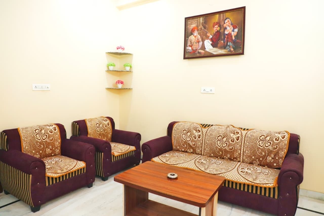 A living room with two sofas, a coffee table, and a wall-mounted shelf with decorative items.