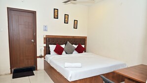 Een slaapkamer met een houten bed, een bureau en een deur.