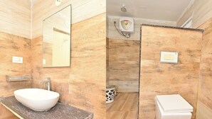 Een badkamer met een wit wastafel, een spiegel, een douche en een toilet.