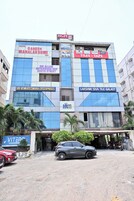 Un edificio a più piani con diversi cartelli di negozi, tra cui un albergo, un negozio di piastrelle e Tile Galaxy.