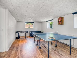 A room with a ping pong table, a foosball table, and a window with a view of greenery. - "Eeske" - 4km from the sea by Interhome (Thisted)