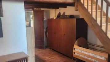 Une pièce avec une mezzanine, un escalier en bois, un lit, un bureau et une chaise.