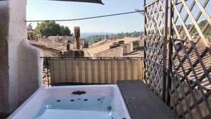 A hot tub with a clear view of a terraced landscape. - The Boat on the Rooftops (Cotignac)