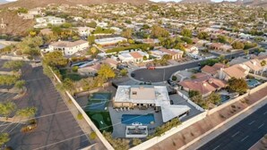 Vista aérea de un barrio residencial con casas, una piscina y una cancha de baloncesto.