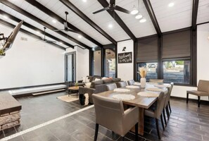 Ein modernes Interieur mit Essbereich, Sofas und Deckenventilator.