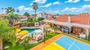 Et boligområde med swimmingpool, udendørs siddepladser og tennisbane.