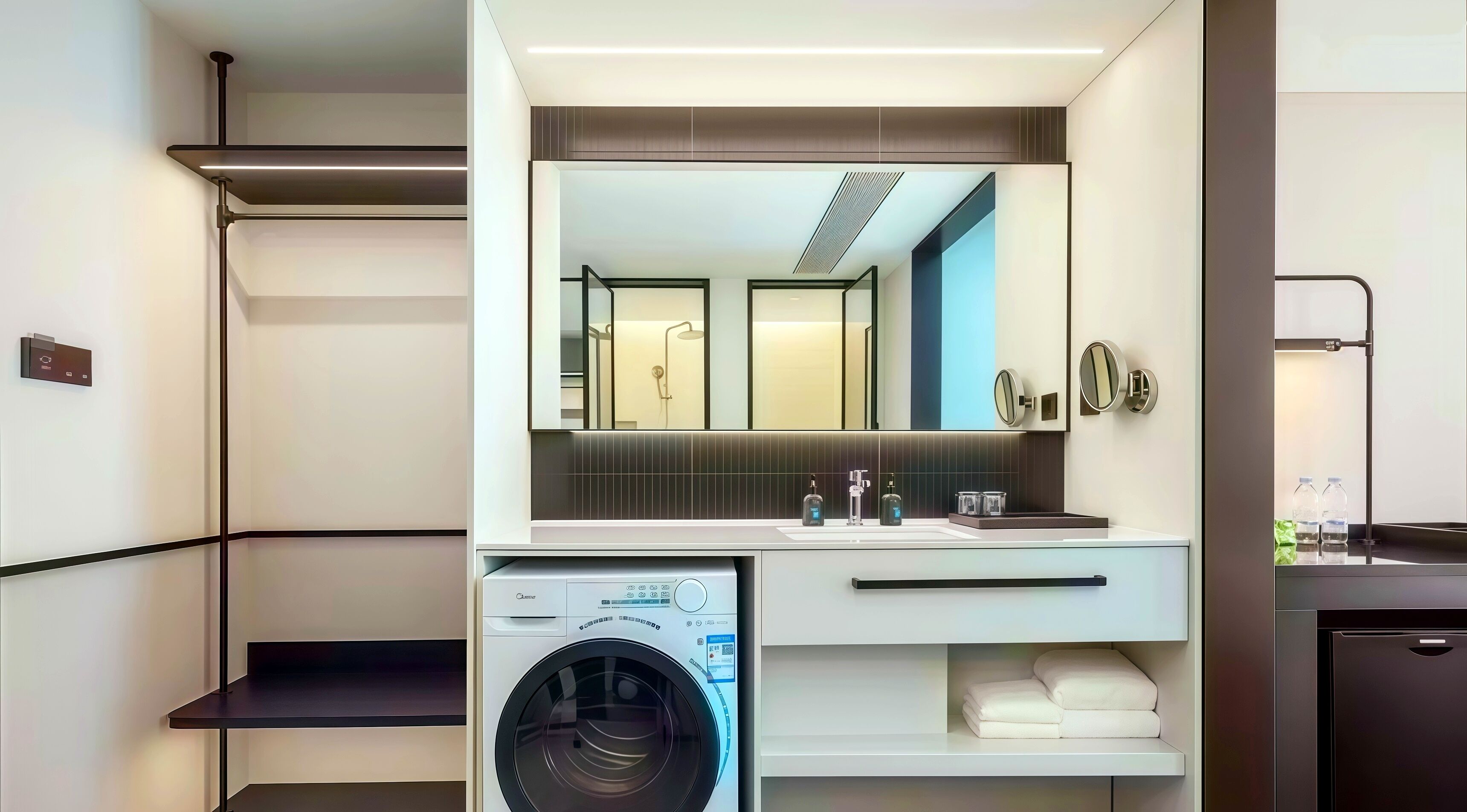 A modern bathroom with a built-in washing machine, a large mirror, and a vanity with a sink and towel storage.