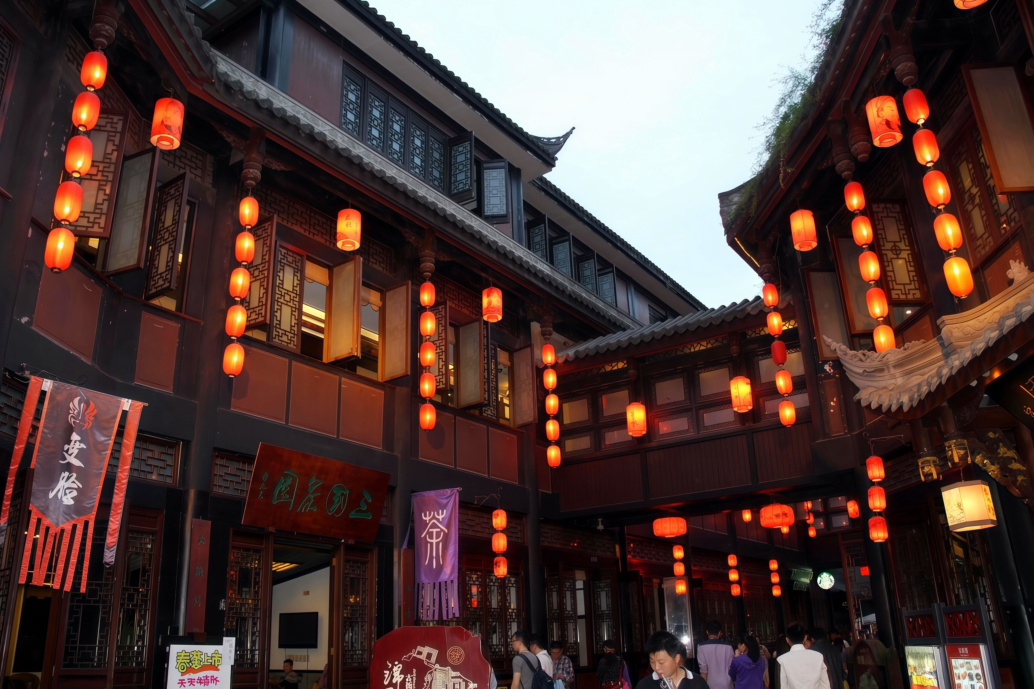A traditional building with multiple levels, ornate wooden railings, and hanging lanterns.