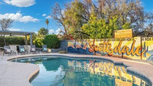 A swimming pool with a mural, lounge chairs, and a pergola. - Ultimate Backyard | Pool, Pickleball, and Golf! (Scottsdale)