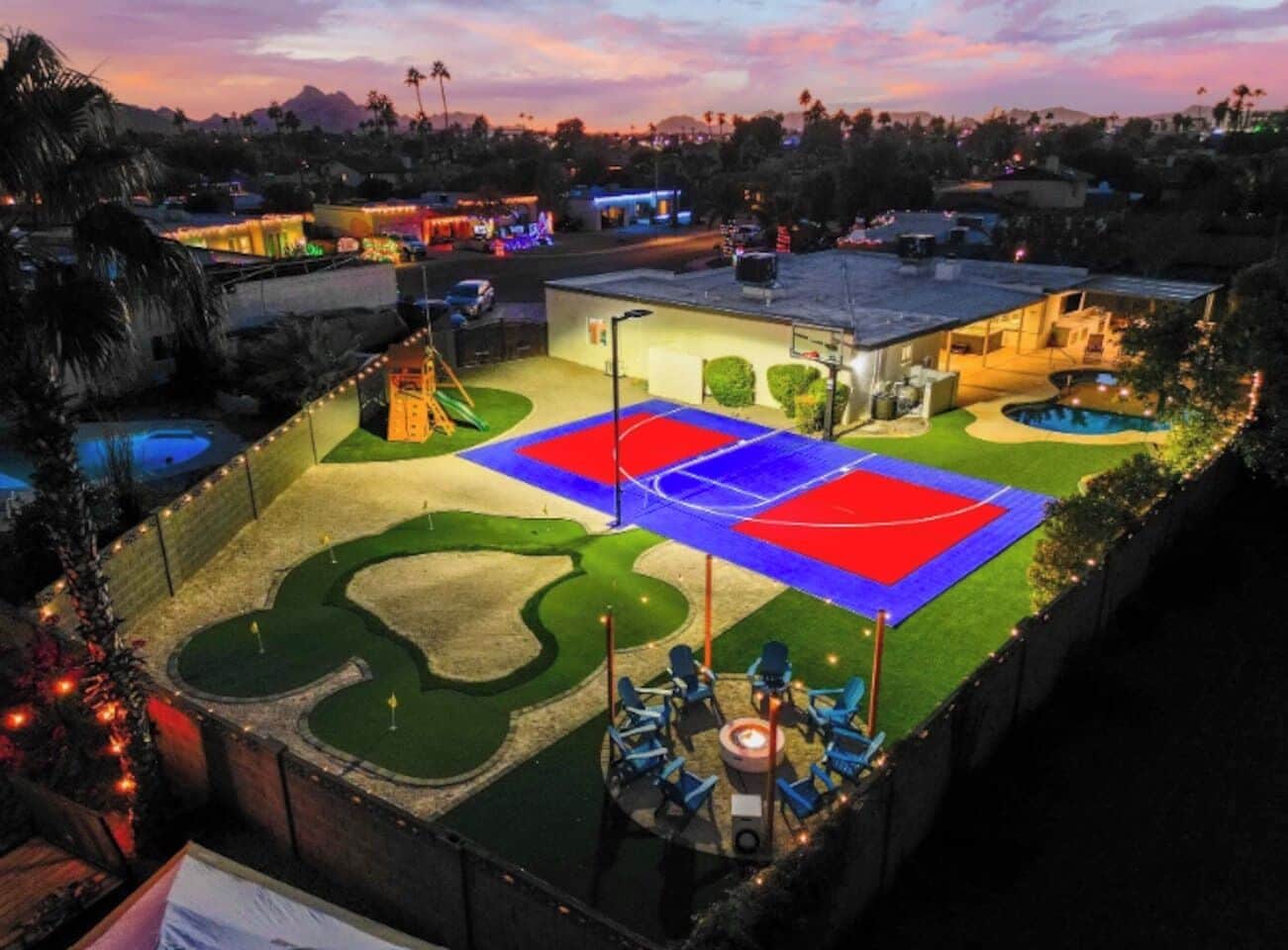 A residential property with a basketball court, swimming pool, and outdoor seating area.