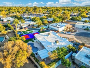 A residential area with multiple houses, a swimming pool, and a landscaped garden. - Ultimate Backyard | Pool, Pickleball, and Golf! (Scottsdale)