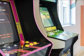 Arcade machines with joysticks and colorful displays. - Ultimate Backyard | Pool, Pickleball, and Golf! (Scottsdale)