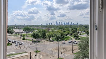 A cityscape with a prominent skyline, a busy intersection, and surrounding greenery.