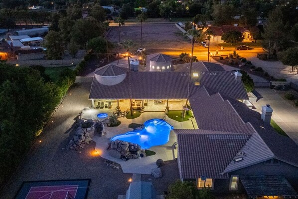 Ein Wohnhaus mit Swimmingpool, Terrasse und guter Beleuchtung.
