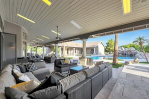 Ein Außenbereich mit Lounge-Möbeln aus Rattan, einem Pool und Blick auf ein Wohngebäude.