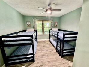 A room with bunk beds, a ceiling fan, and a window with curtains. - Peaceful Lake House with Boat-Friendly Access near Lake Norfork in Mountain Home, Arkansas (Mountain Home)