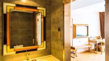 A modern bathroom with a large mirror, a sink, and a shower area.