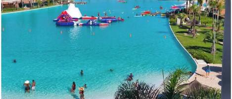 Una gran piscina con múltiples toboganes acuáticos y una zona de playa.