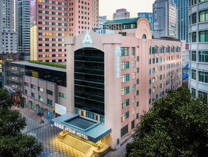 A hotel with a prominent ATOUR sign, multiple floors, and a modern architectural design. - QingdaoWusiguangchangYaduoJiudian (Qingdao)