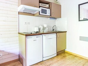 A compact kitchen with a dishwasher, microwave, coffee maker, and a sink. - Les Chalets d'Ax by Interhome (Ax-Les-Thermes)