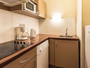 A compact kitchen with a microwave, coffee maker, and dishwasher. - Les Chalets d'Ax by Interhome (Ax-Les-Thermes)