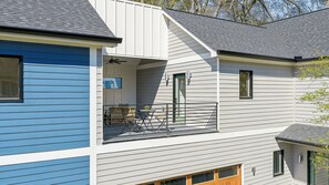 A two-story house with a balcony, a door, and a window. - Your Extended Stay Home | Business Professionals • Travel Nurses • Relocation (Atlanta)