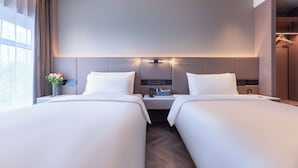 A hotel room with two beds, a bedside table with a lamp, a mirror, and a view of the city. - Atour Hotel, Hisense Plaza, May Fourth Square, Qingdao (Qingdao)