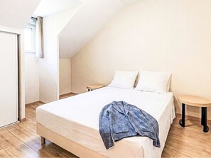 A bedroom with a bed, a window, a door, and a small round table. - Les Chalets d'Ax by Interhome (Ax-Les-Thermes)