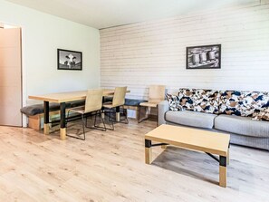 A modern living room with a wooden dining table, chairs, a sofa, and two framed pictures on the wall. - Les Chalets d'Ax by Interhome (Ax-Les-Thermes)