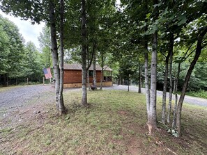 Eine Hütte, umgeben von Bäumen, mit einem Kiesweg, der dorthin führt.