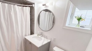 A modern bathroom with a toilet, sink, and shower area. - Executive 1BR Suite | Express Transit to Downtown & Airport | Fast Wi-Fi (Toronto)