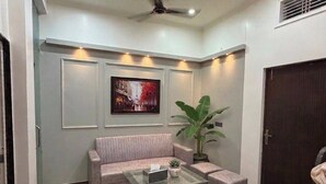 Una habitación con piso a cuadros, un sofá, una mesa de centro, una planta y una puerta.