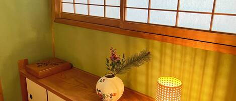A wooden console table with a decorative vase and a lit candle holder.