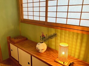 Una consola de madera con un jarrón decorativo y un candelabro encendido.