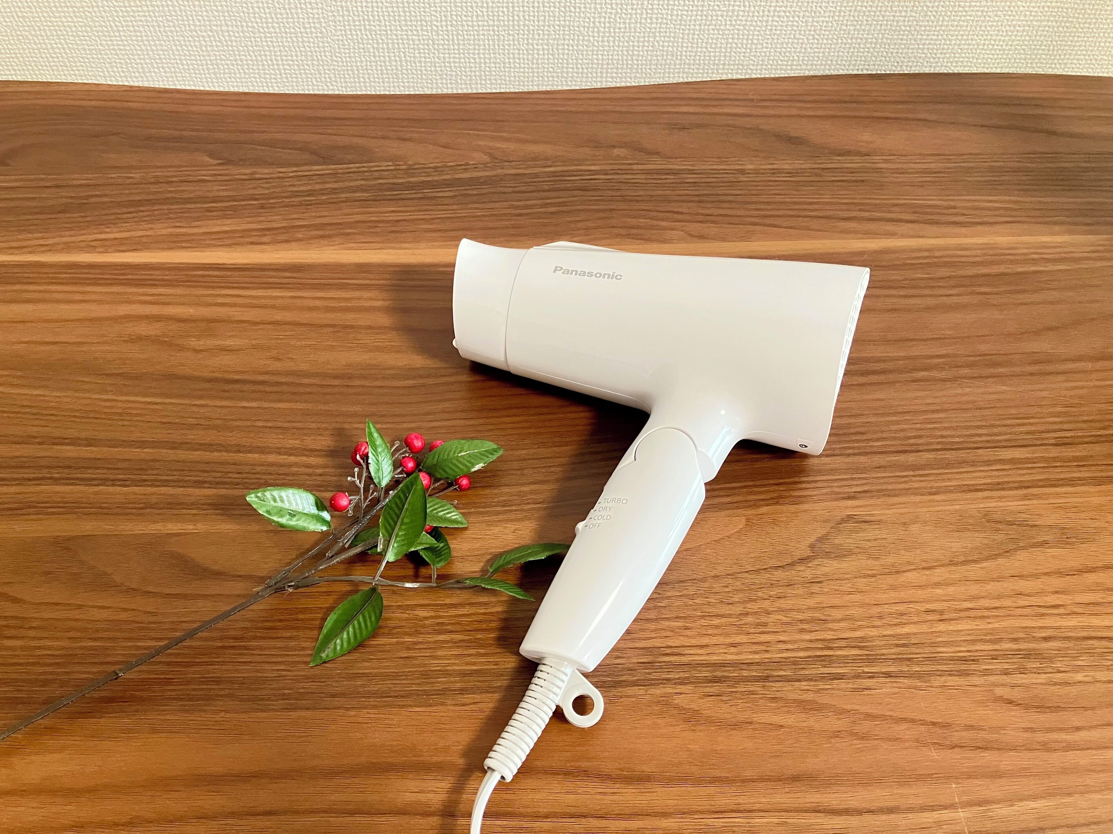 A Panasonic hair dryer on a wooden surface.