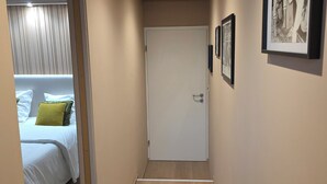 A hallway with a bed, a door, and framed pictures on the wall. - Alsace apartment adjacent to the Domaine de Pairis, Pets allowed, (Orbey)