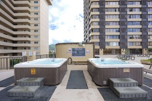 A rooftop pool area with hot tubs and a sign indicating pool rules. - Waikiki 9th Floor Studio with King Size Bed (Honolulu)