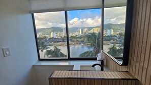 A bathroom with a large window, a sink, and a mirror. - Waikiki 9th Floor Studio with King Size Bed (Honolulu)