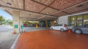 Un estacionamiento con techo estampado, suelo de ladrillo y un coche dentro.
