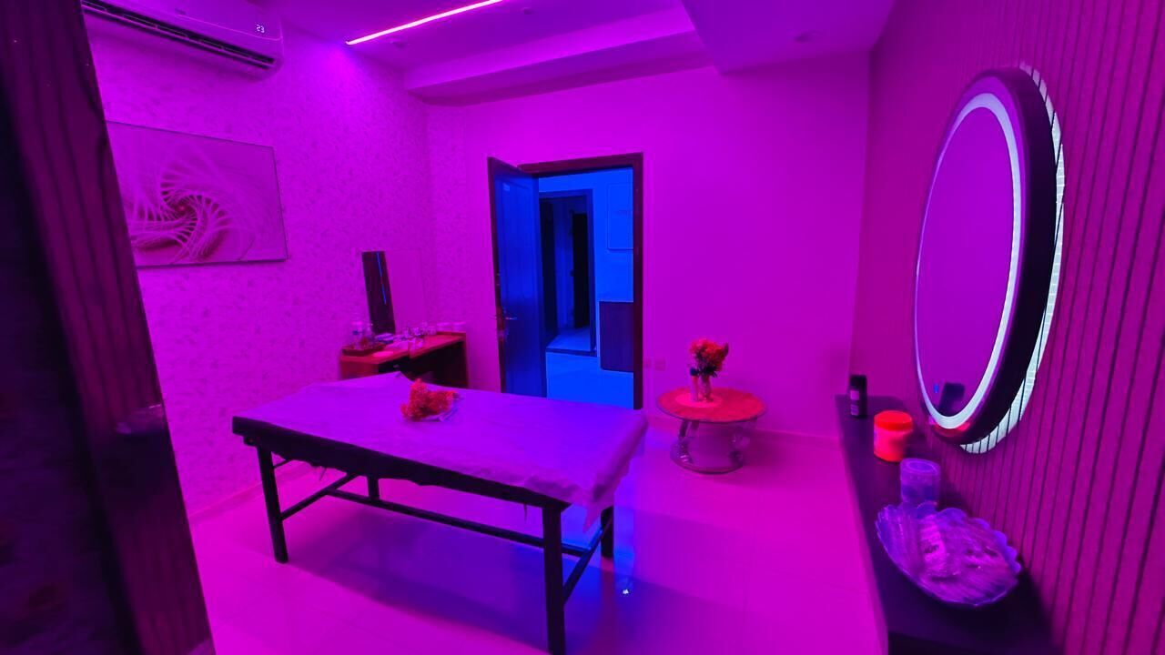 Een kamer met een tafel, een spiegel en een deur naar een andere kamer.