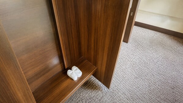 A wooden floor with a carpeted area and a small white object on the floor.