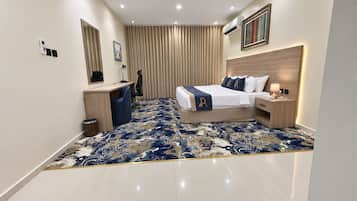 A modern hotel room with a bed, bedside tables, a desk, and a chair.