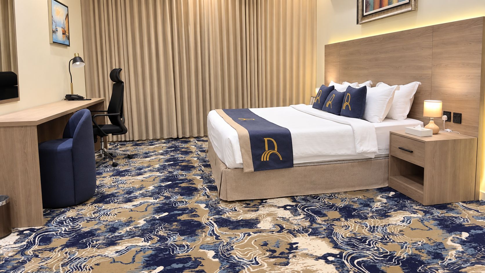 Ein Hotelzimmer mit Bett, Schreibtisch, Stuhl und einem gemusterten Teppich.
