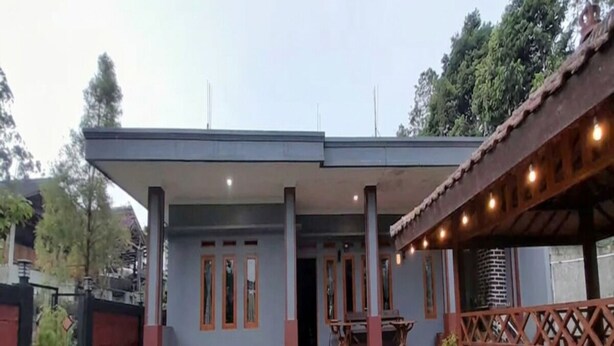 A building with a covered patio, a dining area, and a small garden with two benches. - Cozzy Darmaga Palayangan Pangalengan (pangalengan)